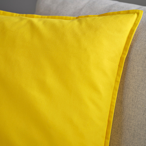 Funda de cojín de color amarillo brillante con costuras limpias, colocada sobre un cojín suave, que muestra tela y artesanía de alta calidad.