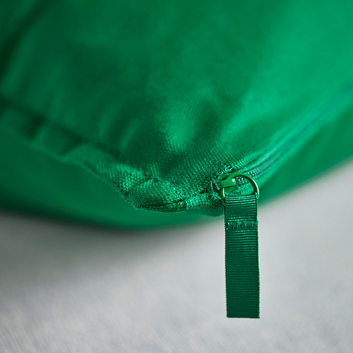 Funda de cojín verde con cremallera duradera, sujeta por un asa resistente, que presenta tejido de algodón reciclado de alta calidad.