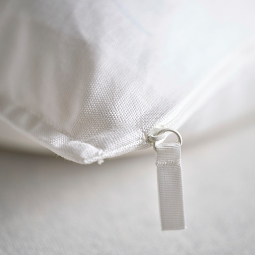Primer plano de la almohada GURLI: cremallera de algodón de calidad, textura suave, blanco impoluto.