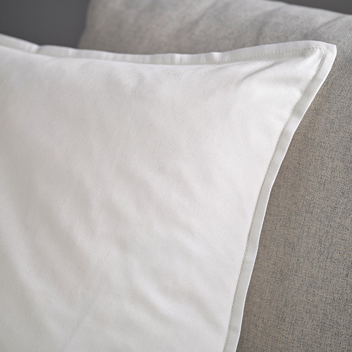 Funda de almohada blanca sobre un sofá, con un tejido suave y de alta calidad con una cremallera limpia.