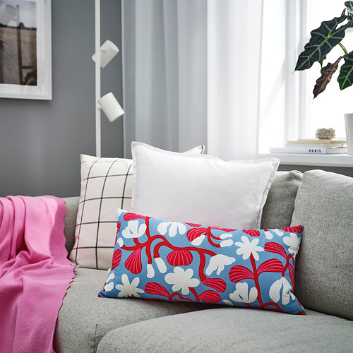 Almohada floral roja y azul sobre sofá gris, colección SANDMOTT, salón moderno.
