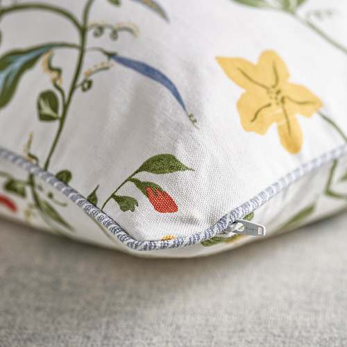 Funda de cojín con cremallera con estampado floral y ribete verde.