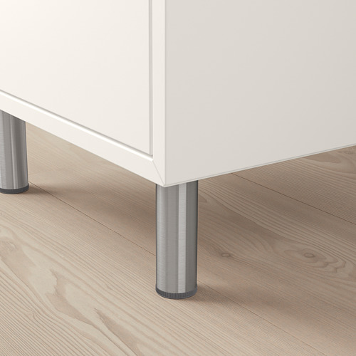 Mueble blanco de piernas largas sobre suelo de madera; Robustas patas metálicas visibles.
