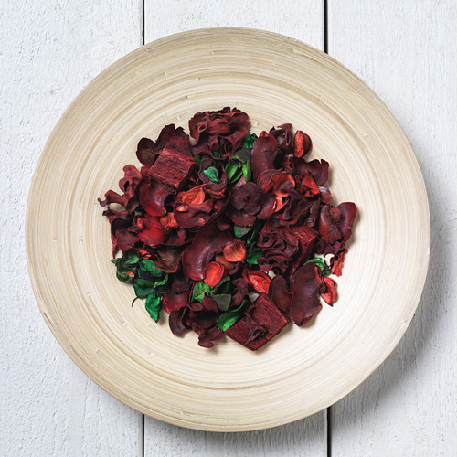 Plato redondo de madera con virutas rojas y hierbas. Hecho a mano, acabado liso.