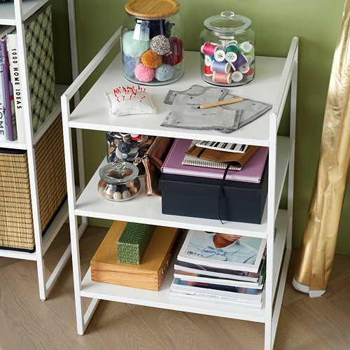 Estantes de almacenamiento JONAXEL blancos con artesanías, libros y artículos de decoración, con frascos de vidrio y recipientes de tela.