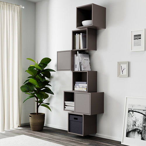 Sala de estar moderna con estantería EKET, libros, decoración, planta cerca de la ventana.