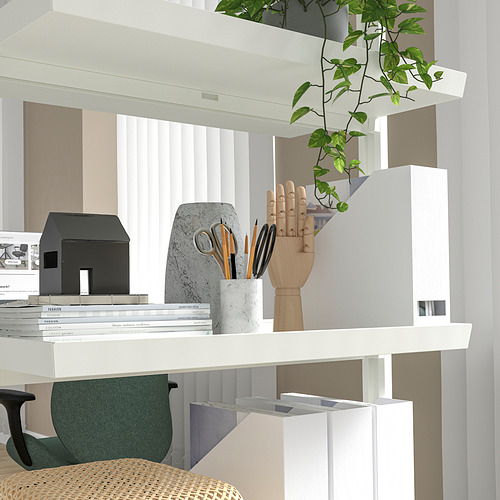 Moderna oficina con libros, jarrón para bolígrafos y decoración de plantas.