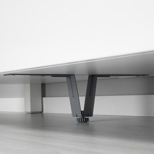 Soportes de patas de metal negro ocultos debajo de muebles blancos, mejorando la estabilidad.