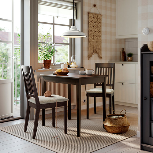 Acogedor rincón de cocina con mesa de madera oscura junto a un gran ventanal.