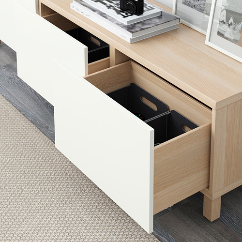 Cómoda moderna con cajón abierto con compartimentos de almacenamiento negros. La parte superior muestra elementos decorativos, incluida una cámara.