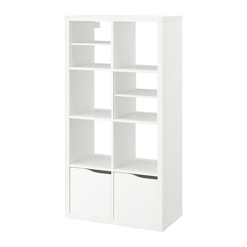 Una estantería KALLAX blanca con varios compartimentos y cajones, de diseño moderno.