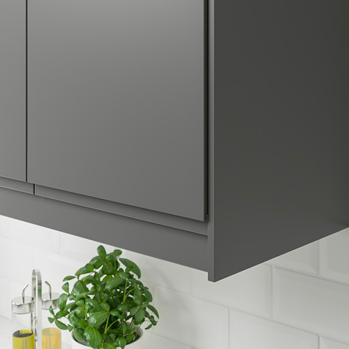 Los bordes de los armarios de cocina de color gris oscuro ocultan la iluminación y los cables, con un diseño moderno y elegante.