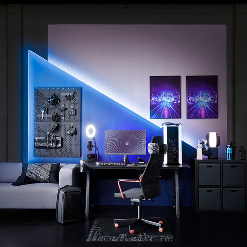 Moderna oficina en casa con pared decorativa en azul, elegante escritorio, silla de juego, accesorios ergonómicos y arte de pared.