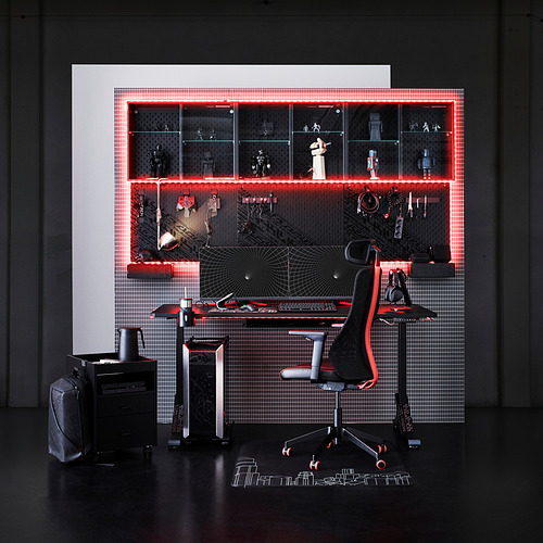 Sala de juegos con colchoneta LÅNESPELARE, silla negra, escritorio y estanterías iluminadas en rojo con figuritas.