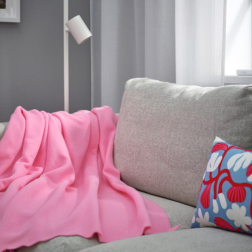 Acogedor sofá gris con manta polar DAGGKÅPOR de color rosa brillante y almohada floral. Poliéster suave y reciclado que cubre casualmente el reposabrazos.