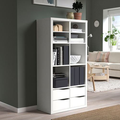 Estantería blanca KALLAX con libros, decoración y almacenaje en el salón.