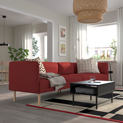 Sofá modular LILLEHEM rojo en la sala de estar, decorado con cojines, sobre lámpara colgante tejida, cerca de la ventana con cortinas blancas.