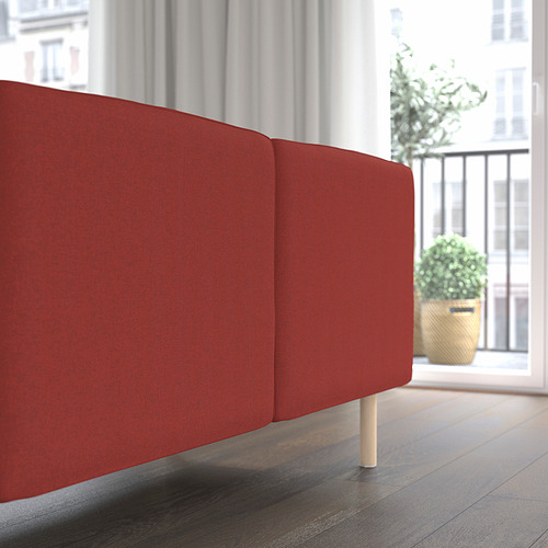 Sofá modular rojo en espacio moderno, grandes cojines, patas de madera. Perfecto para asientos relajados.