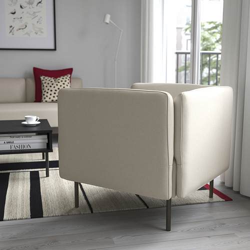 Sala de estar moderna con sofá LILLEHEM, gran ventanal, mesa de centro negra y almohada roja. Pared gris con lámpara y arte.