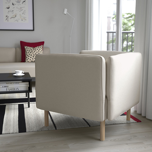 Sala de estar moderna con sofá LILLEHEM beige, mesa de centro, alfombra y ventana alta.