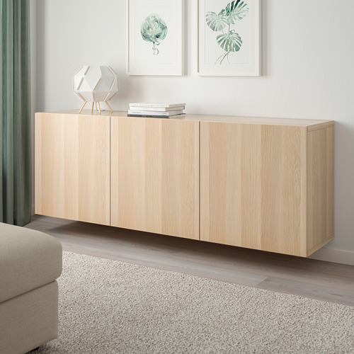 Mueble de almacenaje BESTÅ con puertas en la habitación, madera neutra, alfombra, sofá.