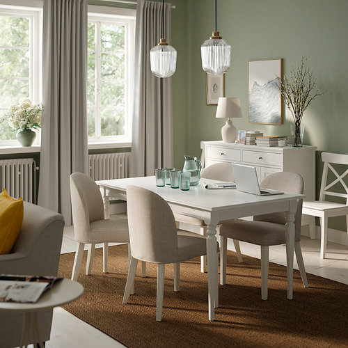 Sala de estar moderna con mesa ROSENTORP, sillas beige y decoración natural.