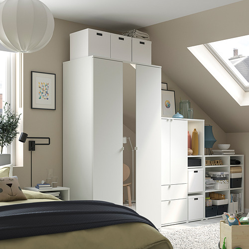Dormitorio moderno con almacenamiento VIHALS blanco, cama, ropa de cama verde/negra, tragaluz, arte, accesorios.