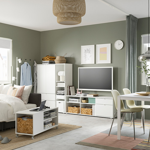 Sala de estar moderna con paredes verdes, con un mueble de TV VIHALS blanco, una cama acogedora y una alfombra redonda.