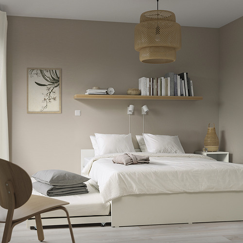 Dormitorio moderno con cama VIHALS, nido, almacenaje, estantería, lámpara, arte y silla.