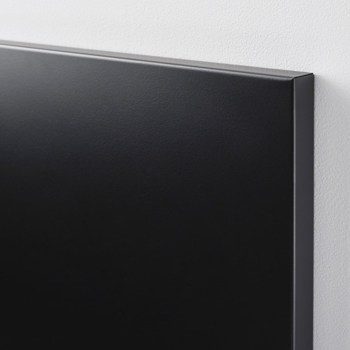 Primer plano de una elegante pizarra magnética negra con una superficie metálica lisa con recubrimiento en polvo, cuidadosamente montada en una pared limpia.