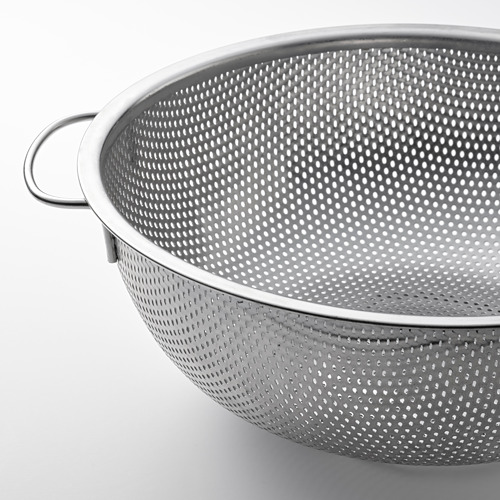 Colador de acero inoxidable con diseño perforado y asas para facilitar el escurrido.