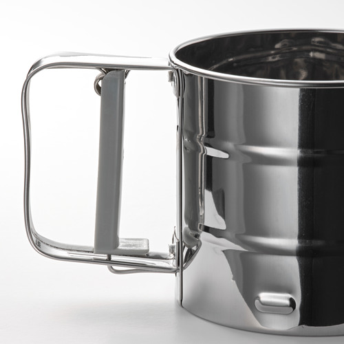Tamiz de harina de plata con mango gris, construcción metálica robusta, diseño elegante.