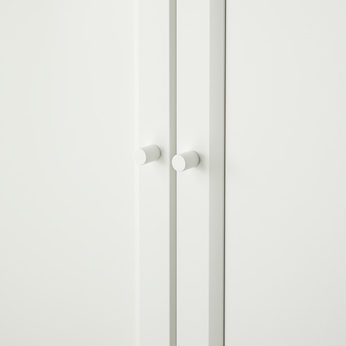 Librería blanca con dos puertas y pomos cerrados, con un diseño limpio y minimalista.