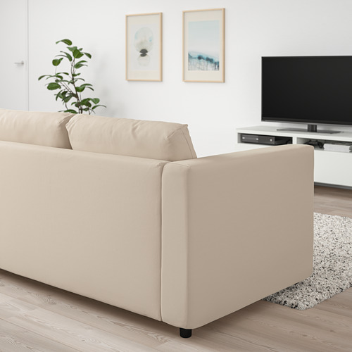 Un sofá VIMLE beige en una sala de estar. Es un sofá de 3 plazas con un diseño minimalista, líneas modernas y es más grande que los elementos de decoración circundantes.