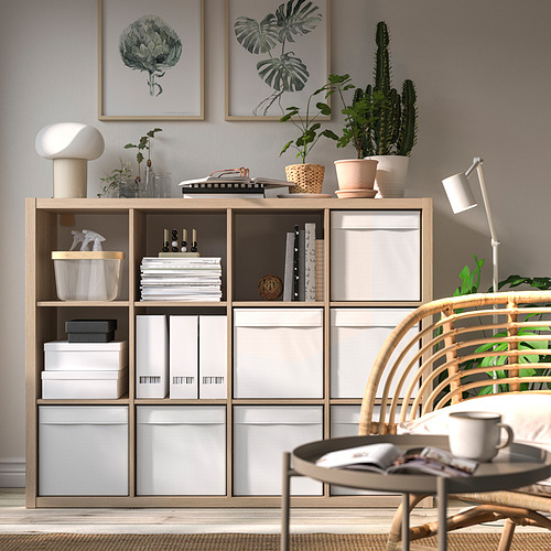 Moderna oficina en casa con estantería kallax, cajas DRÖNA, plantas, arte y silla de mimbre.