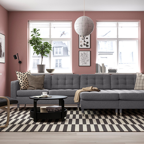 No. Sofá modular LANDSKRONA, gris, patas cromadas, cojines estampados, alfombra. Ventanas, lámpara colgante, planta.