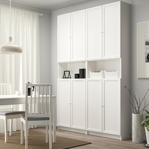 Librería BILLY blanca con puertas empotradas, alta, minimalista, en zona de comedor con silla.