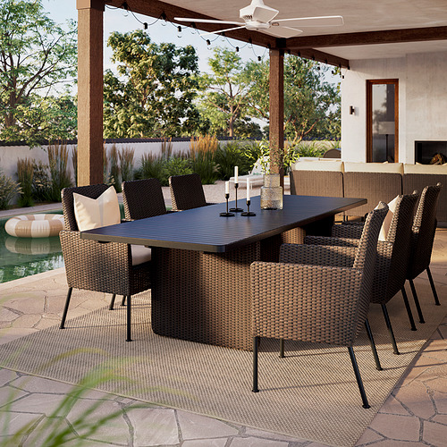 Gran juego de comedor de exterior VITTSKÄR con sillas de mimbre marrón oscuro y mesa rectangular, apto para 8 personas, bajo pérgola.