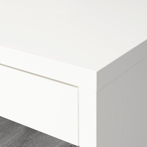 Un rincón limpio y blanco de una configuración de oficina minimalista con una artesanía precisa y superficies lisas y modernas.