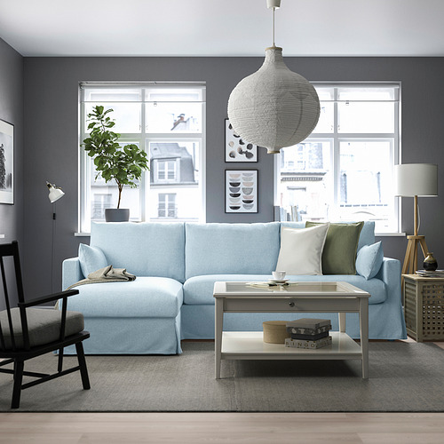 Sala de estar moderna con mueble modular, tumbona de almacenamiento, mesa de centro, lámparas, mecedora.
