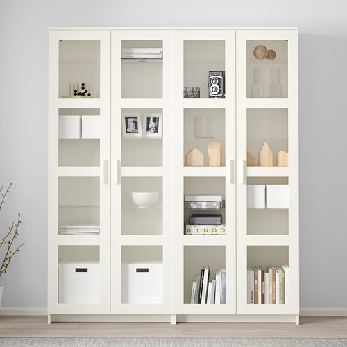 Vitrina blanca con puerta de cristal BRIMNES y estantes ajustables para libros y decoración.