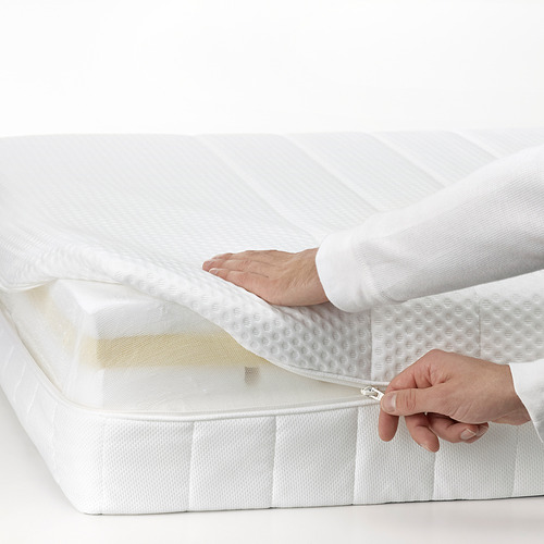 Una persona está abriendo la cremallera de un colchón de espuma blanca, destacando su funda extraíble y lavable para facilitar la limpieza.