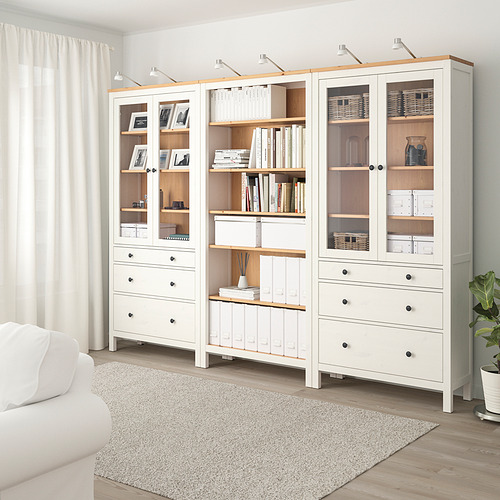 Mueble HEMNES blanco con puertas y cajones de cristal, con capacidad para libros y decoración, minimalista y que domina la habitación.