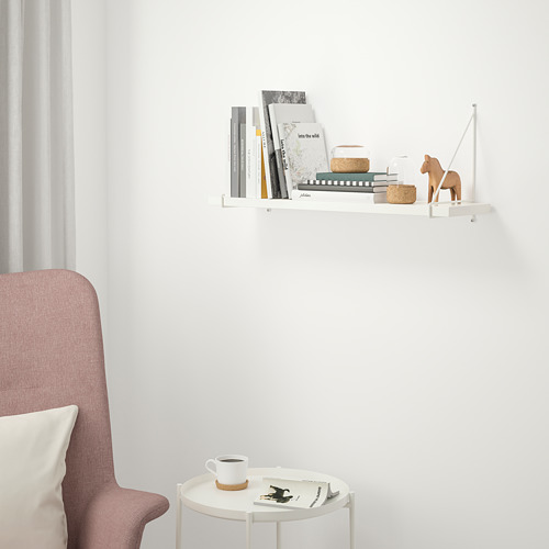 Estantería blanca BERGSHULT con libros, decoración y silla.