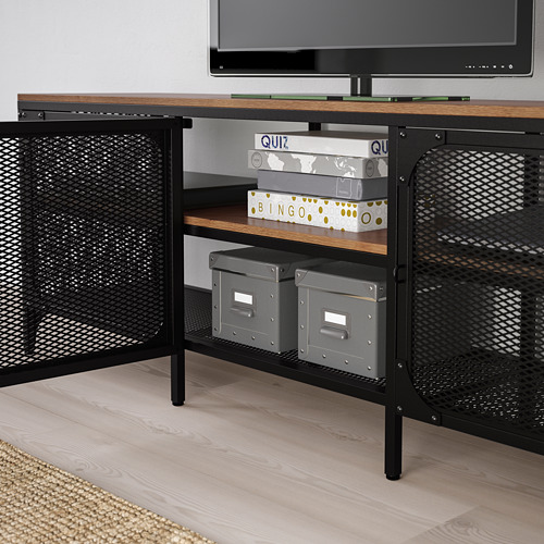 Mueble de TV de metal y madera negra con puertas de malla, almacenamiento de cajas de juegos y contenedores, sosteniendo un televisor en la parte superior.