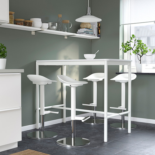 Cocina moderna y minimalista con cuatro taburetes JANINGE blancos, diseño elegante y bases metálicas. Pared gris, encimera blanca y lámpara colgante.