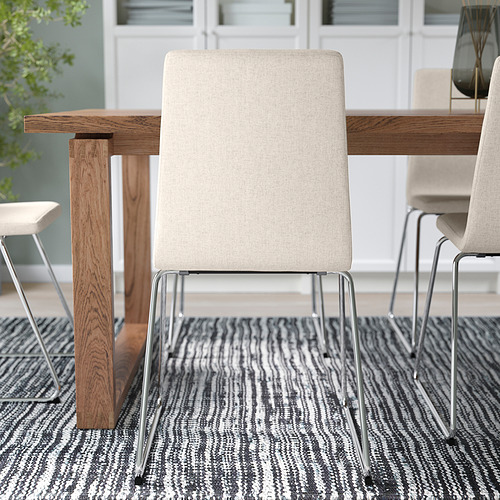 Silla de comedor moderna con funda extraíble de color beige, base de patín metálica y asiento acolchado. Ideal para una fácil limpieza y espacio limitado.