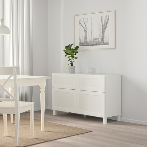 Aparador blanco BESTÅ con 2 cajones cerca de la mesa de comedor y las sillas, planta, habitación luminosa.