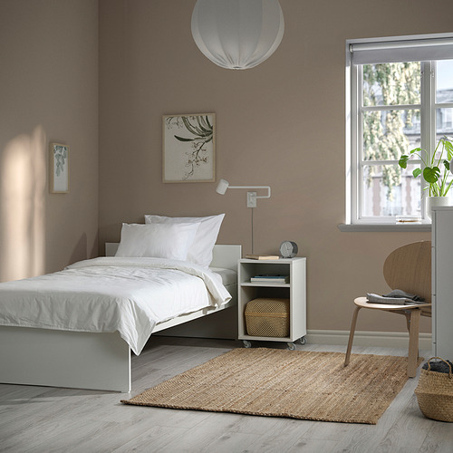 Dormitorio minimalista con cama VIHALS, blanco, suelo de madera, paredes beige, alfombra blanca, mesita de noche, decoración sencilla.