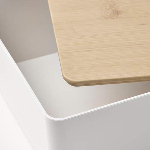 Primer plano de una caja de plástico blanca con tapa de madera clara, que muestra un diseño suave y elegante.